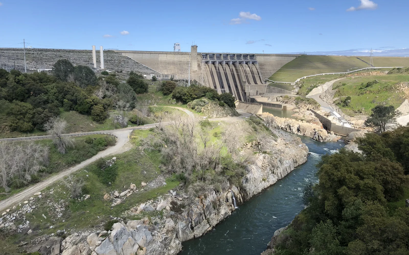 Folsom Dam photographed from the American River bike path lookout, showing modern infrastructure and engineering
